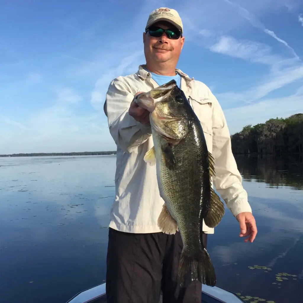 Angler holding up a largemouth bass.