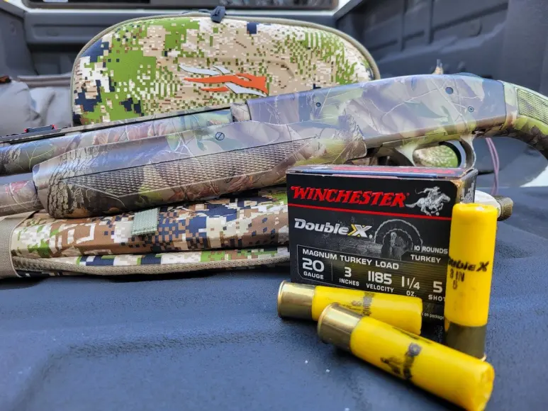 Winchester Double X Magnum Turkey Load shotshells sitting on truck bed with shotgun