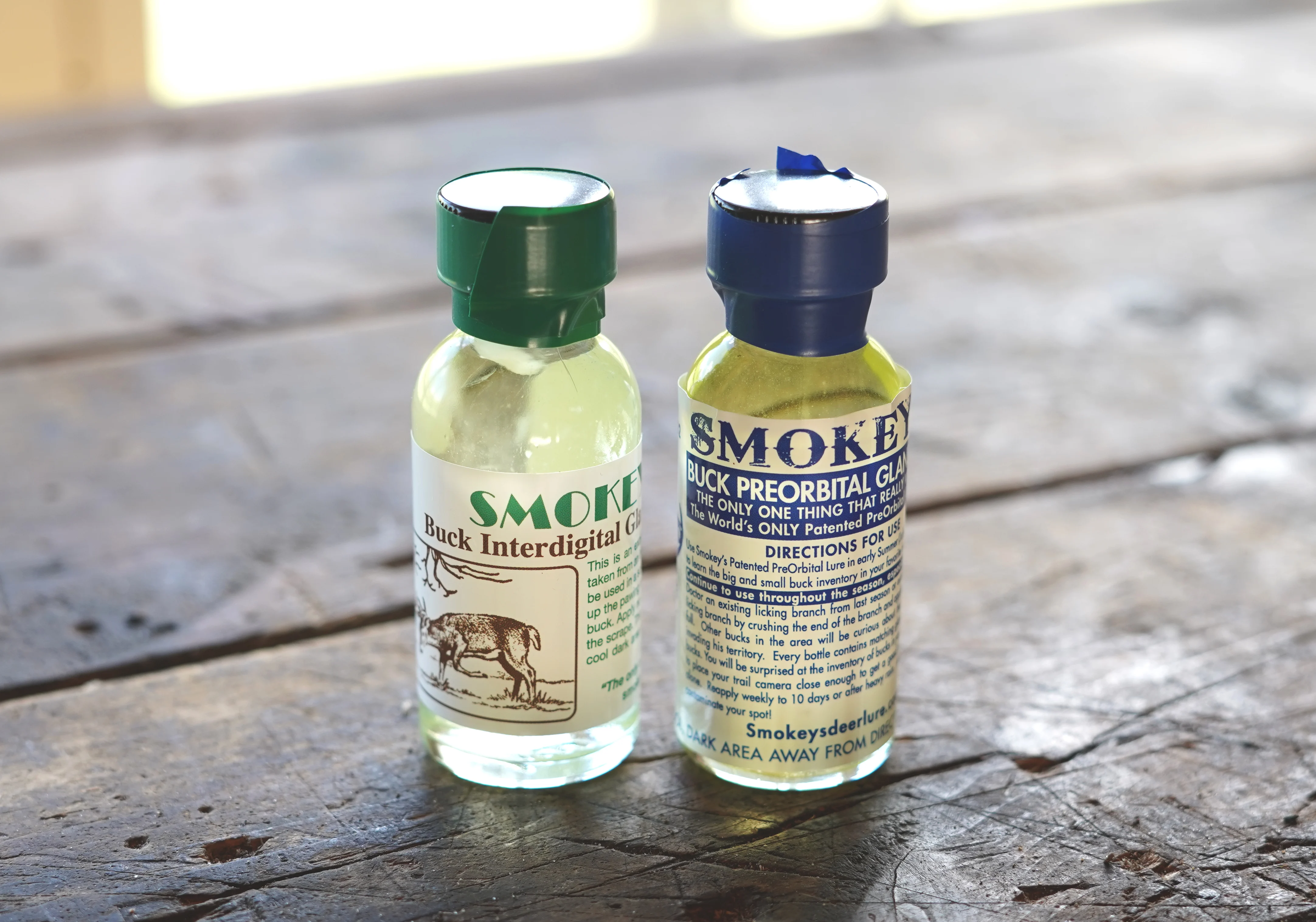 Two bottles of of deer scent on a table. 