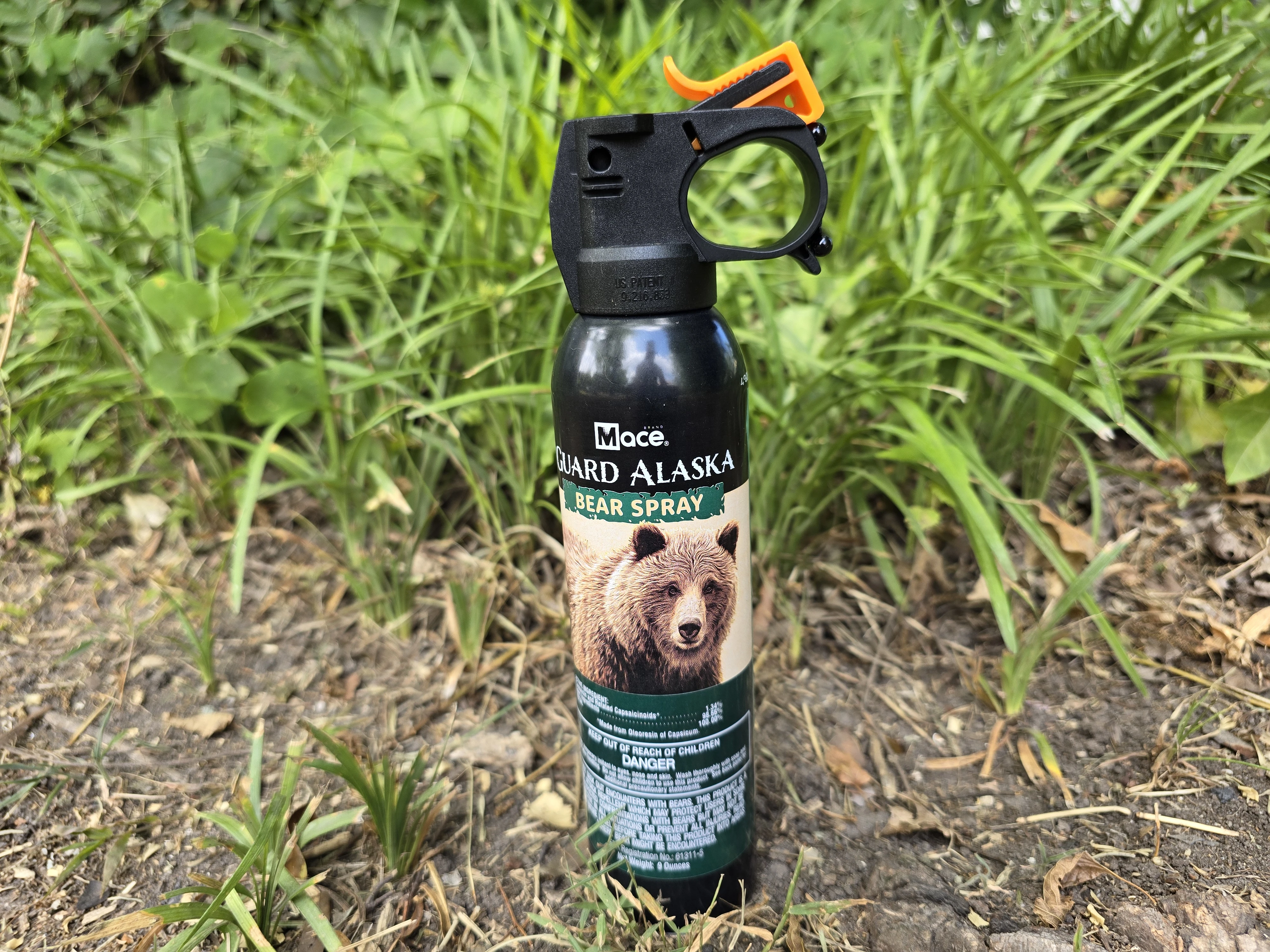 Mace Guard Alaska Bear Spray sitting in grass