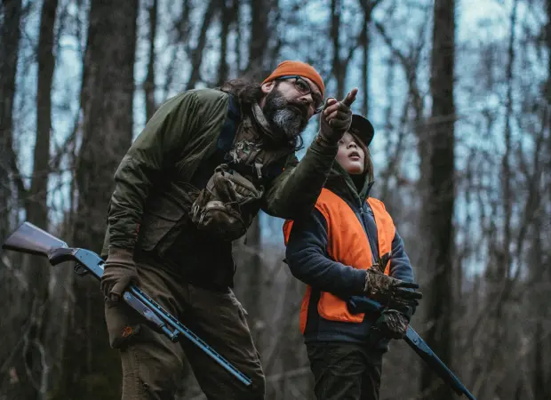 Father and son hunting for squirrels in the woods.