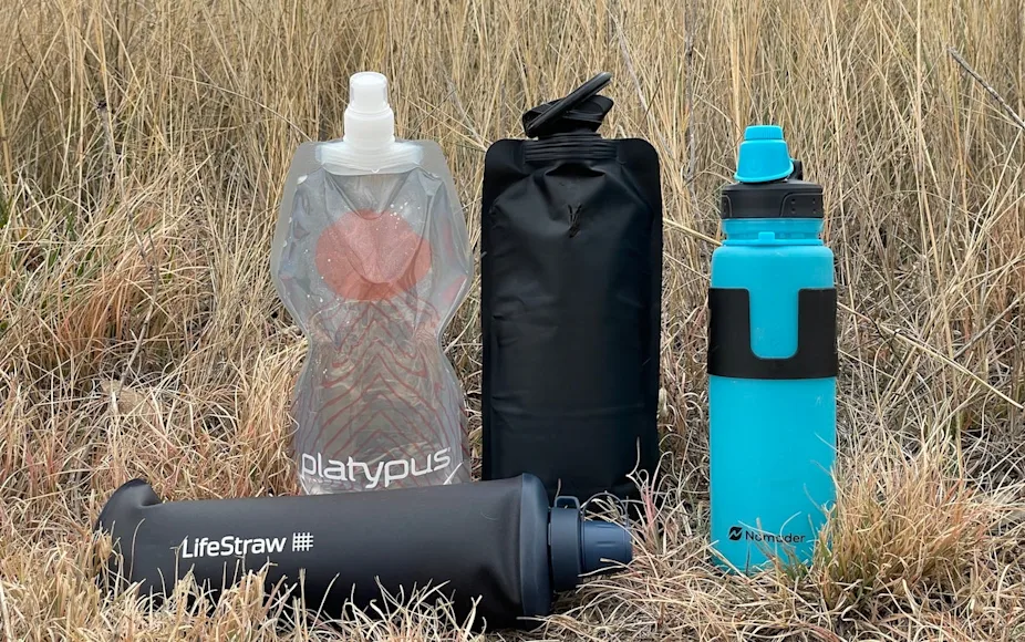 Collapsible water bottles lined up in grass