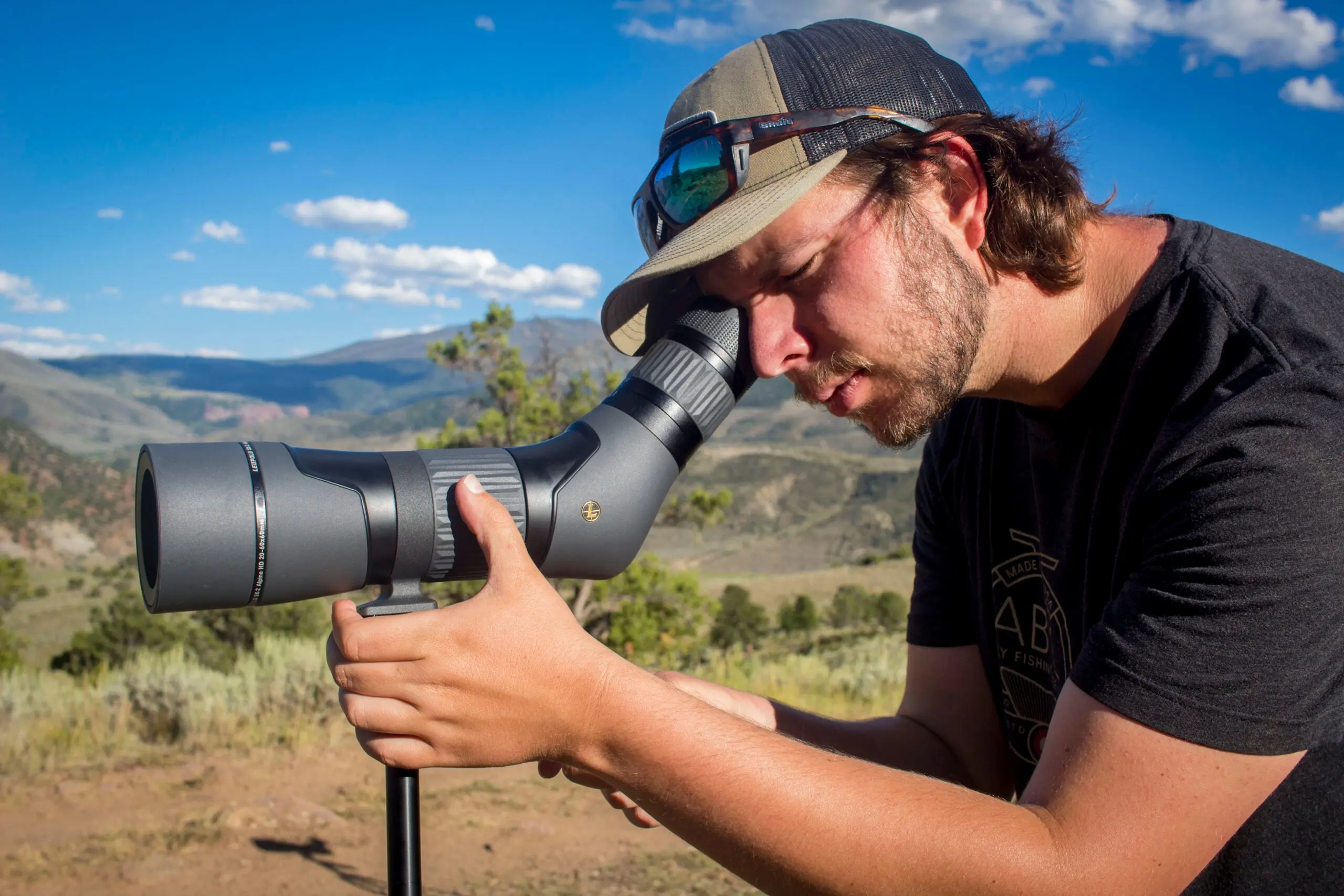 man looking through spotting scope