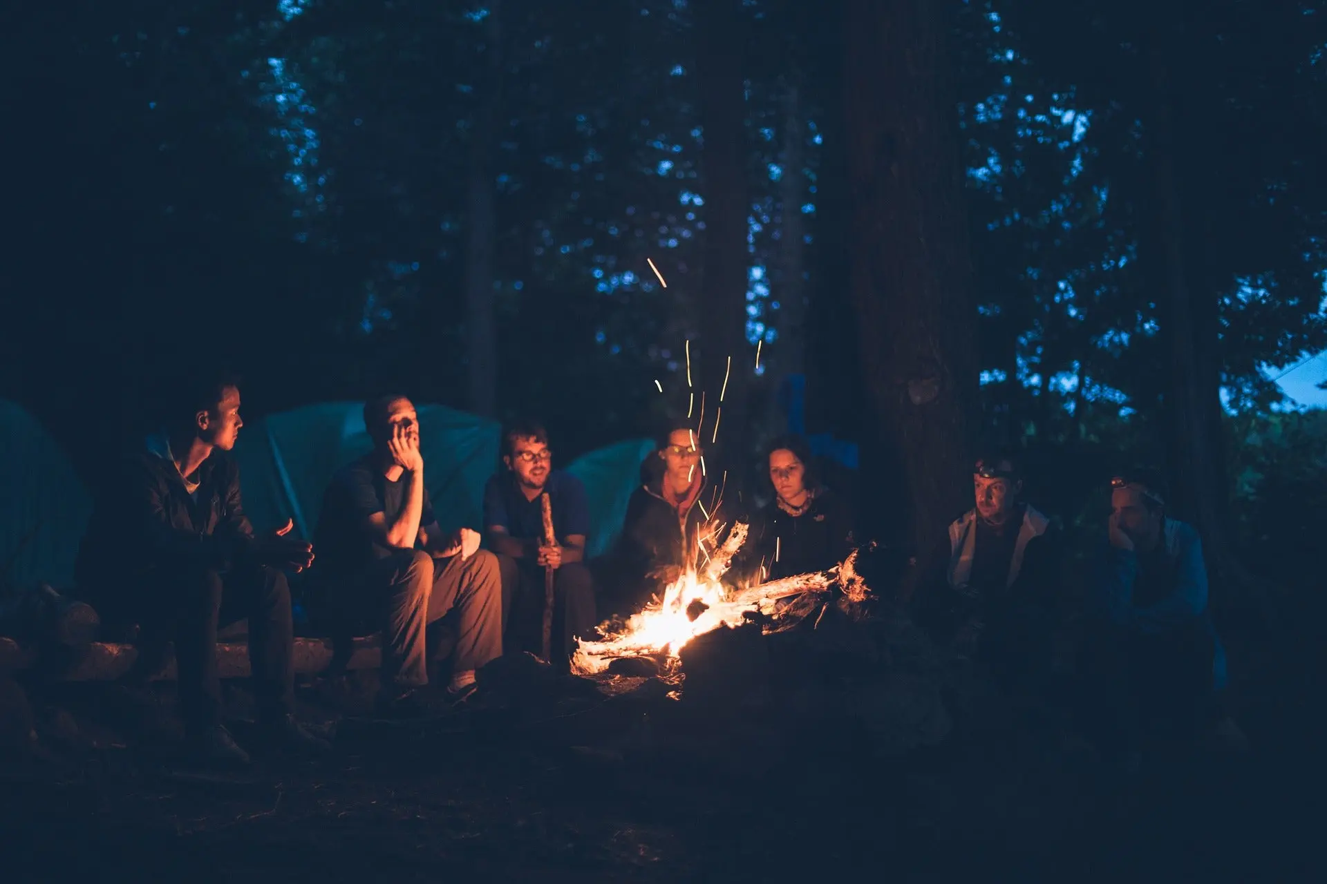 How to start a fire: camper sitting around a fire. 