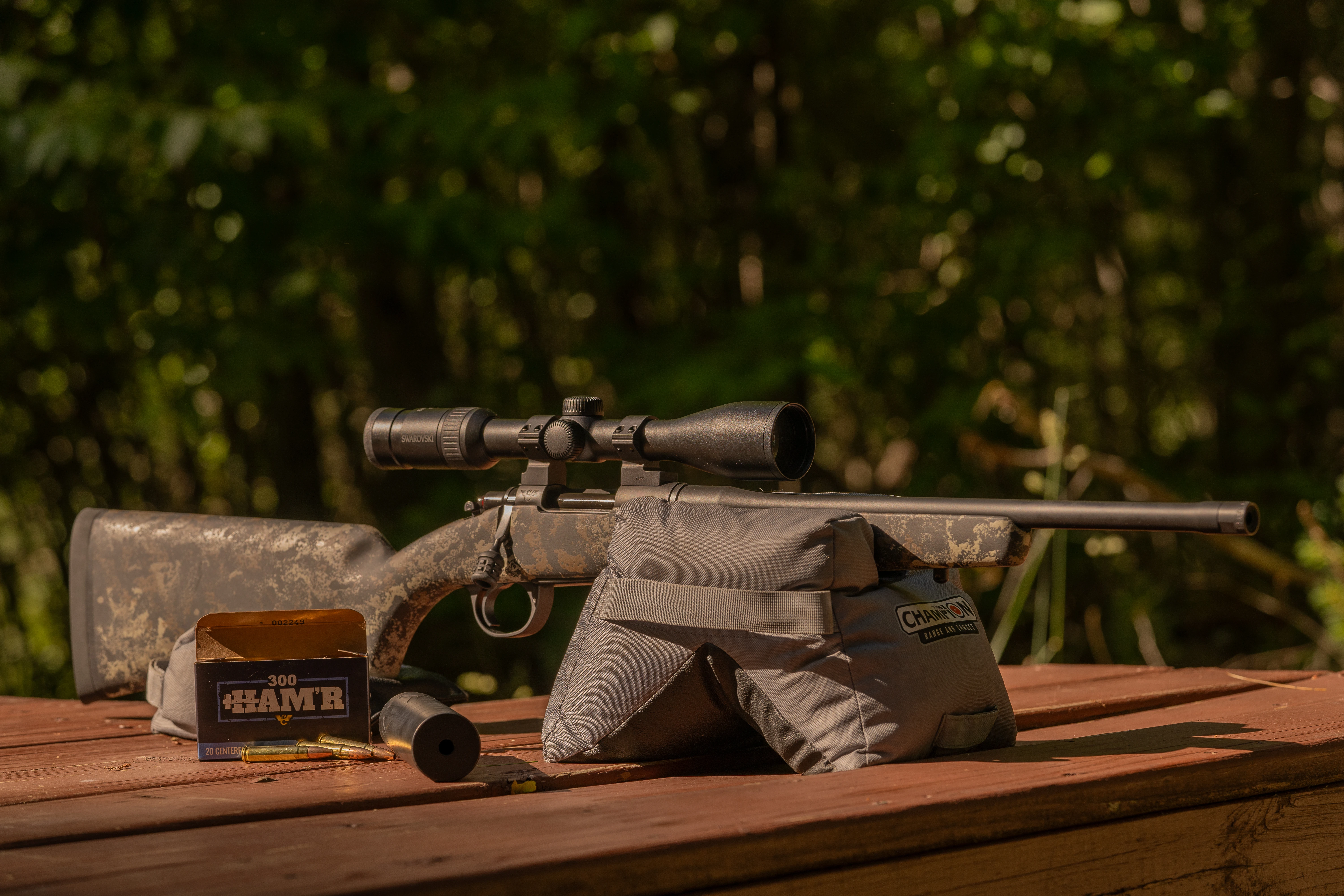 Wilson Combat NULA Model 20 rifle on a bench with sandbags and ammo. 