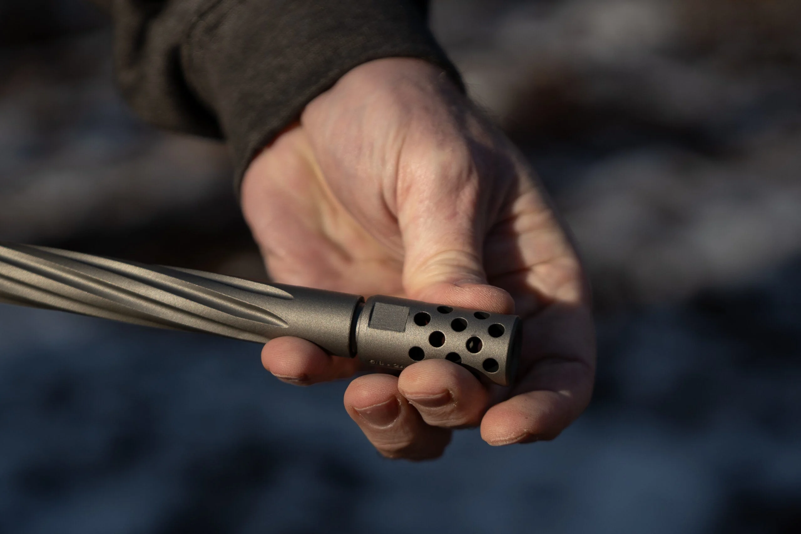 Screwing a muzzle brake onto the threaded barrel of a Ruger American Gen II rifle