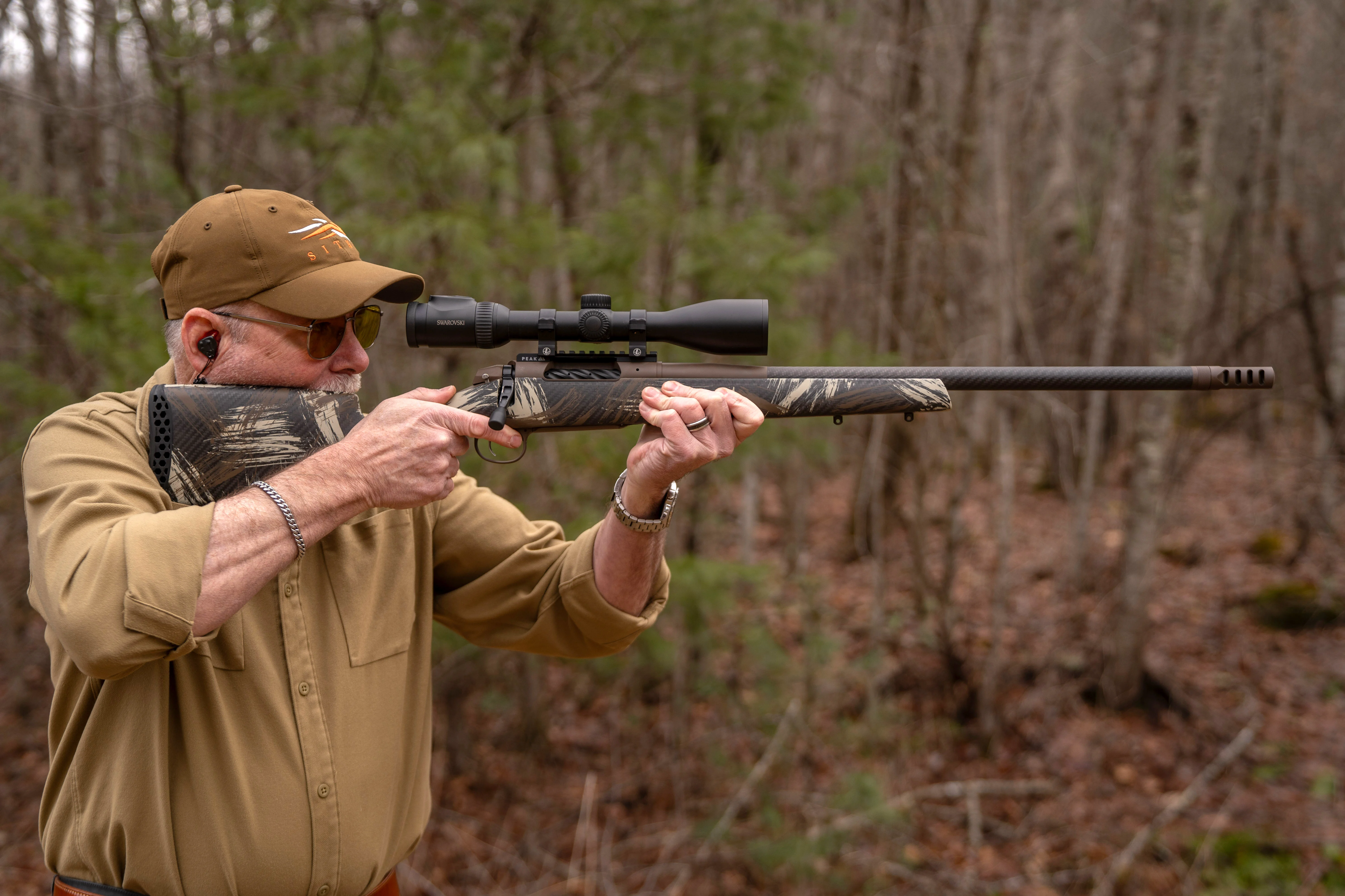 A shooter fires the Model 307 Alpine CT rifle from the off-hand position.