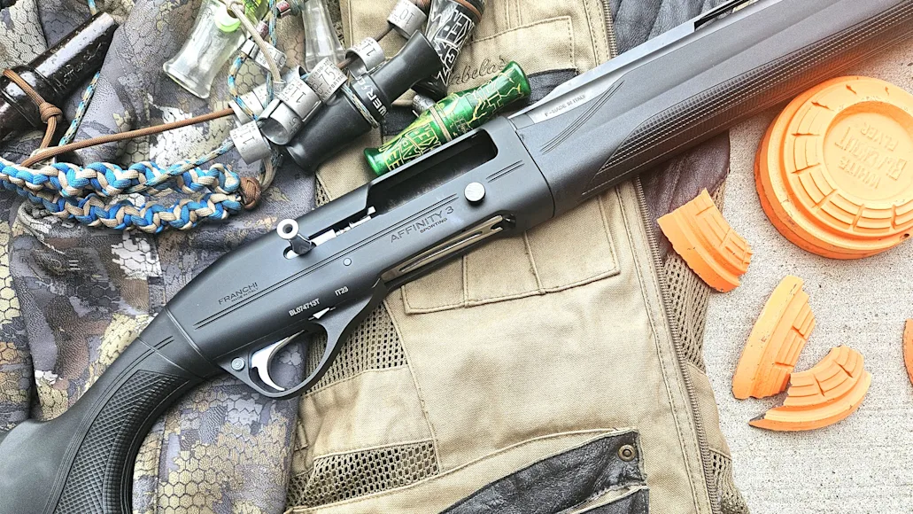 The new Franchi Affinity 3 Sport Trap shotgun resting on a shooting vest with clay targets and duck calls nearby.