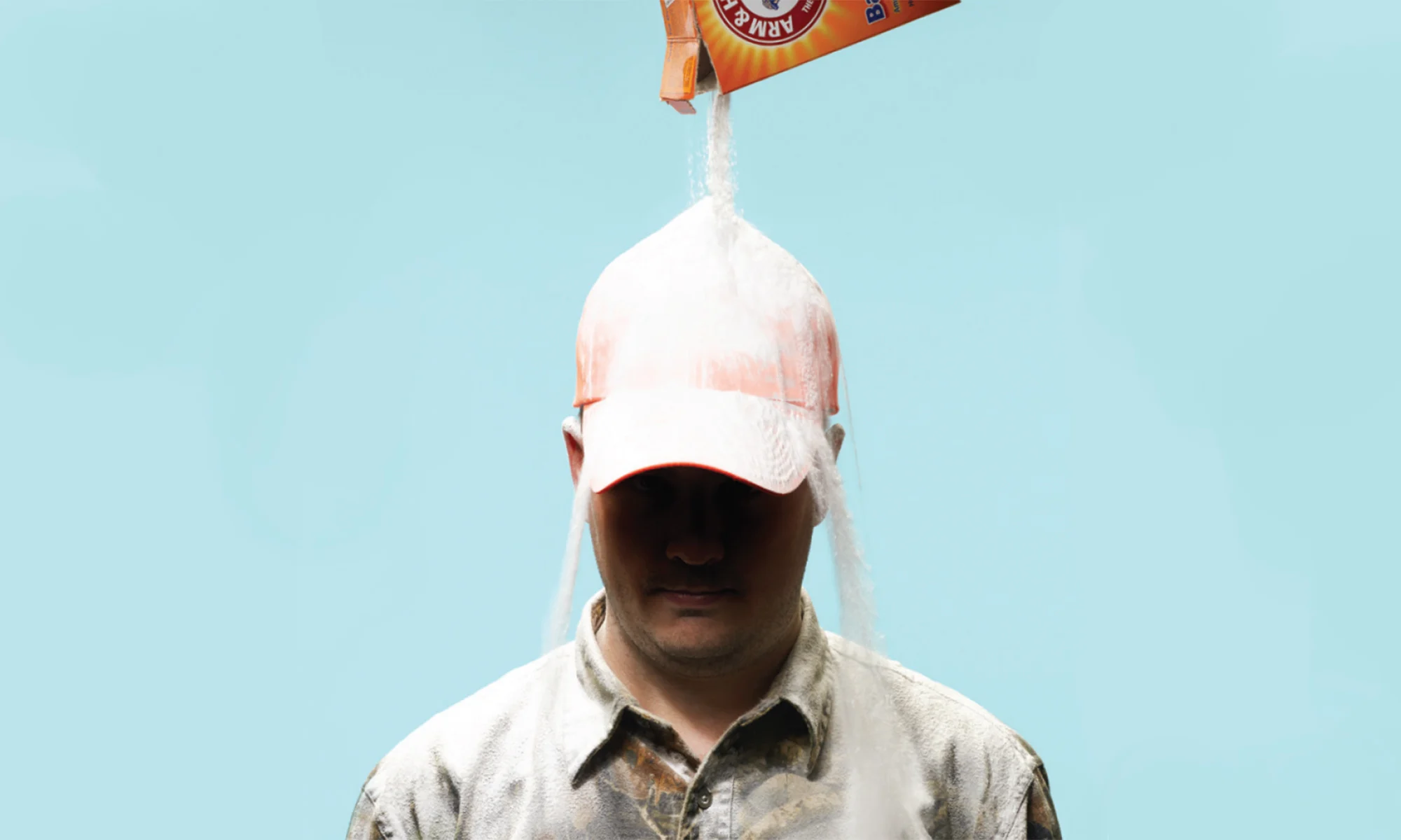 A hunter in camo getting baking soda poured over his head.