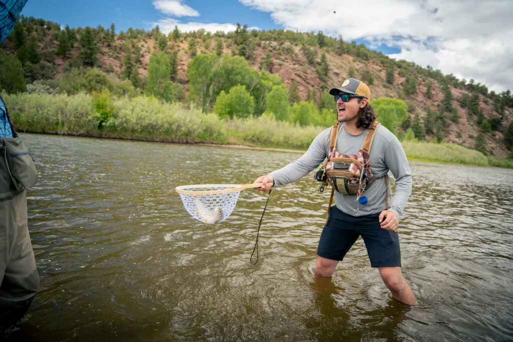 Jennings Hester, who founded Fishing the Good Fight, helps another angler with the net.