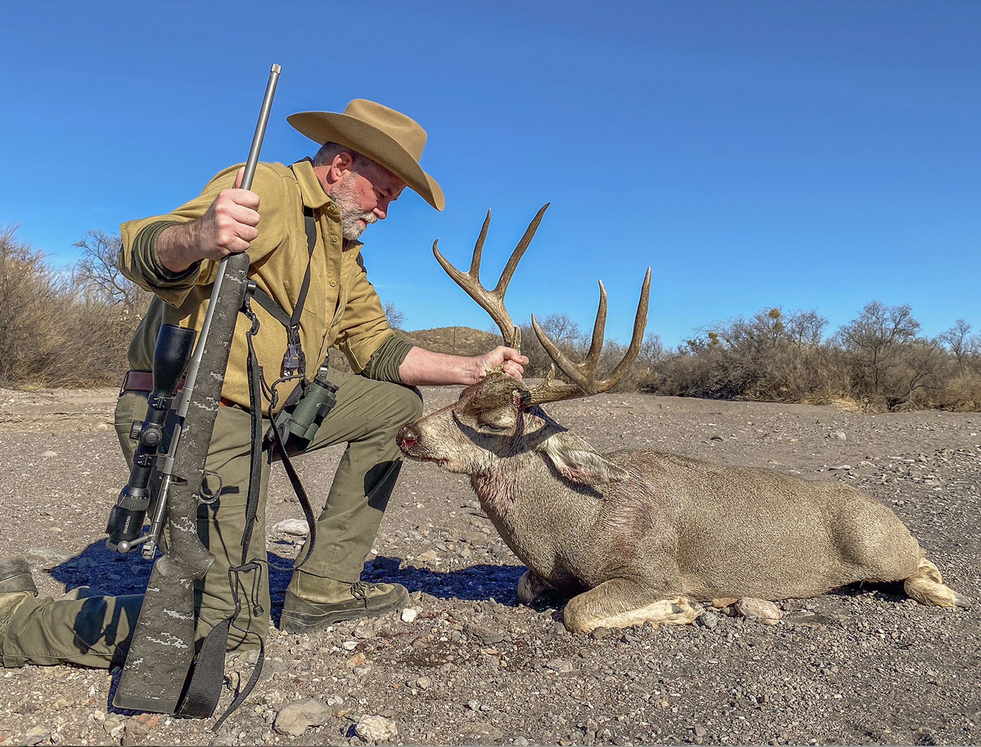 A hunter poses with a whitetail buck.