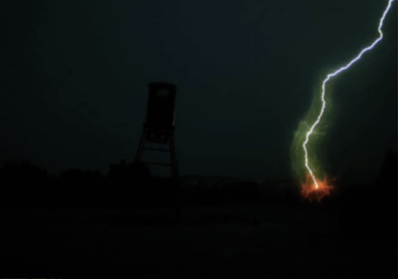 Trail camera photo of a lightning strike near a deer feeder.