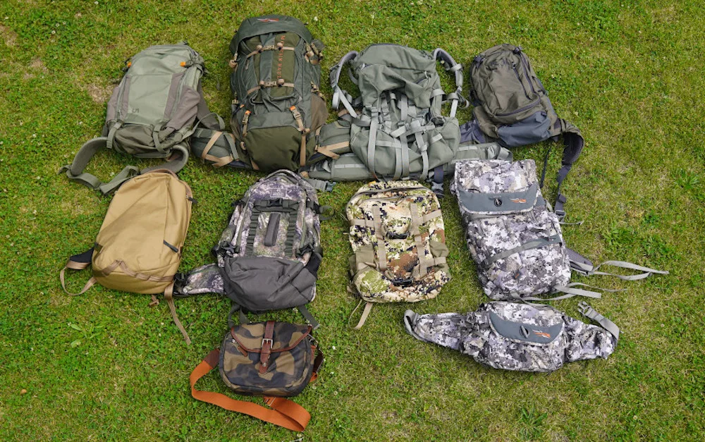 Assorted best hunting packs laid out on grass