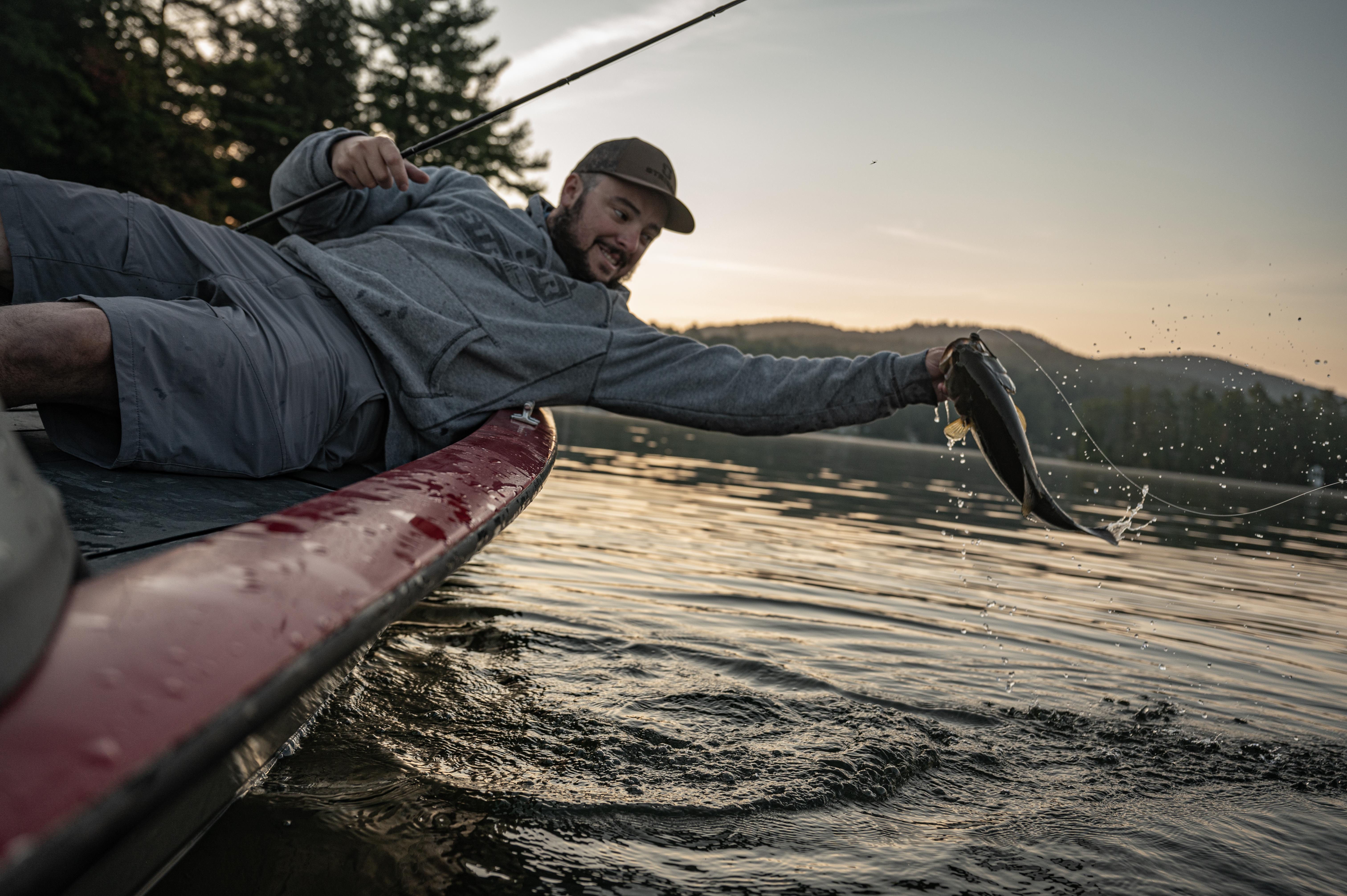 Angler holding bass over water