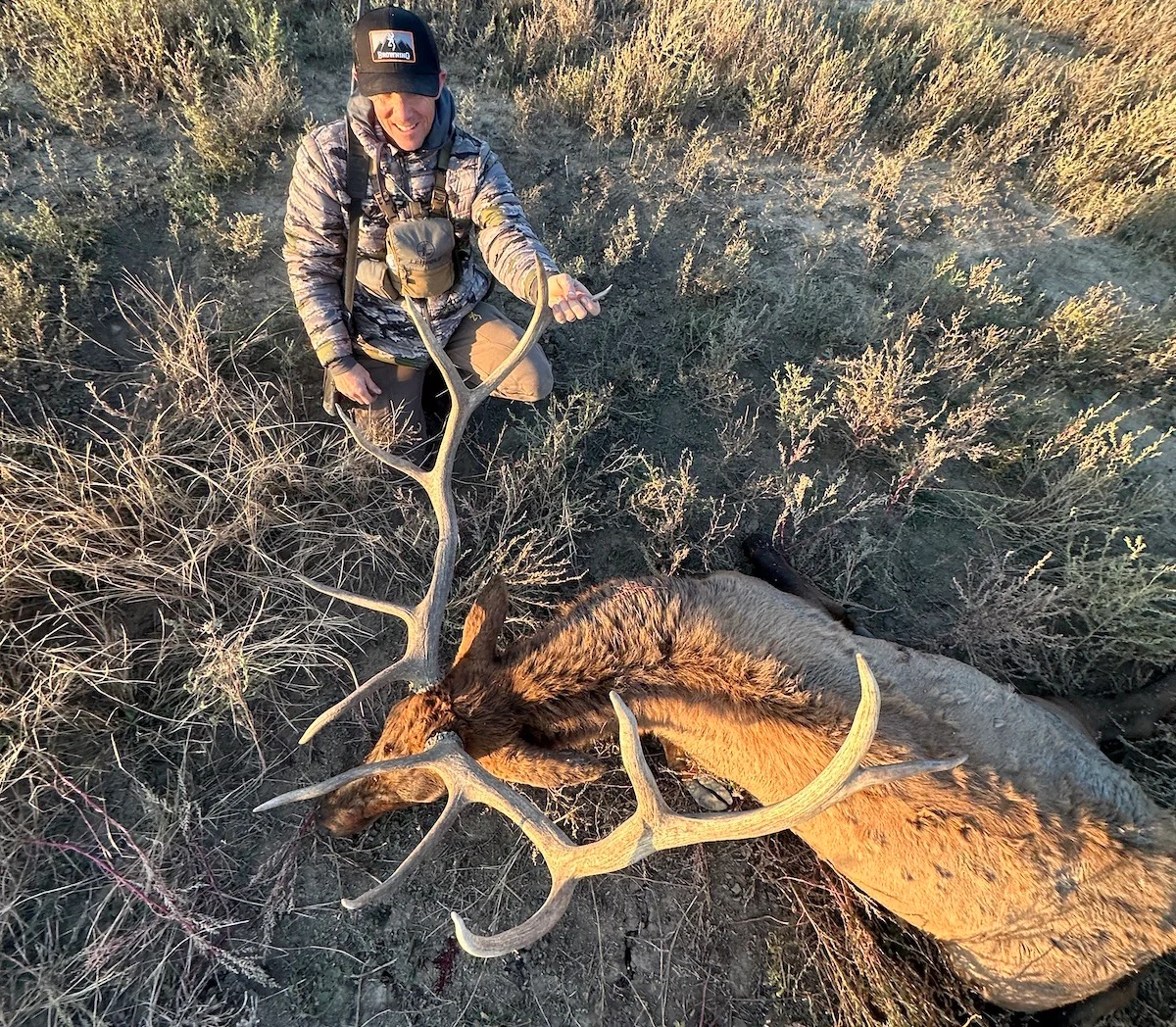 A hunter poses with a bull elk. 