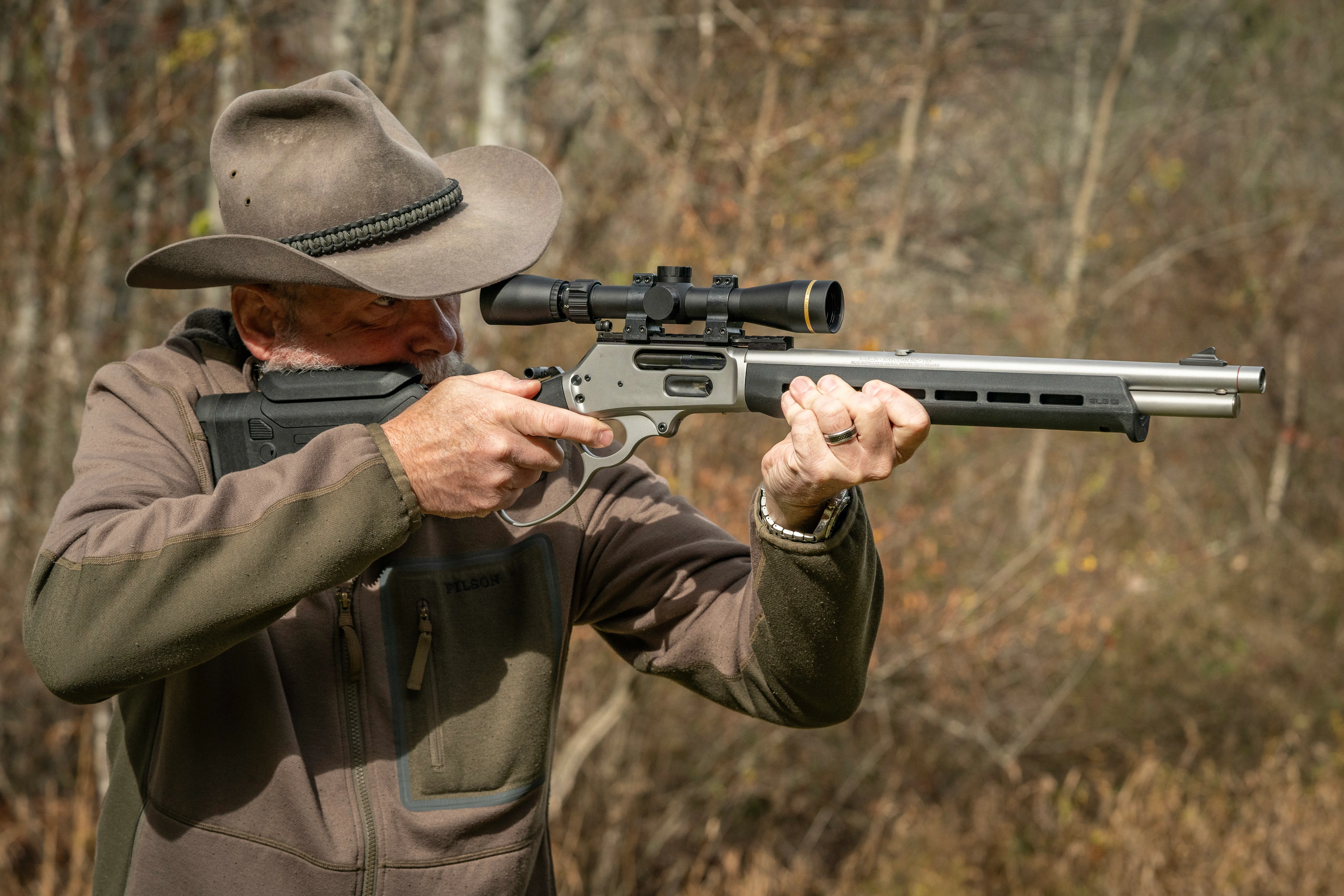 A shooter fires Marlin's new 1895 Trapper model with Magpul stock with woods in the background. 