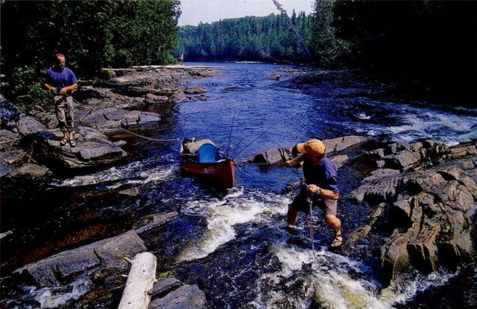 The adventurers line their canoes through a rapid.