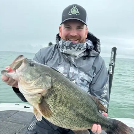 An angler poses with the New York state record for largemouth bass. 