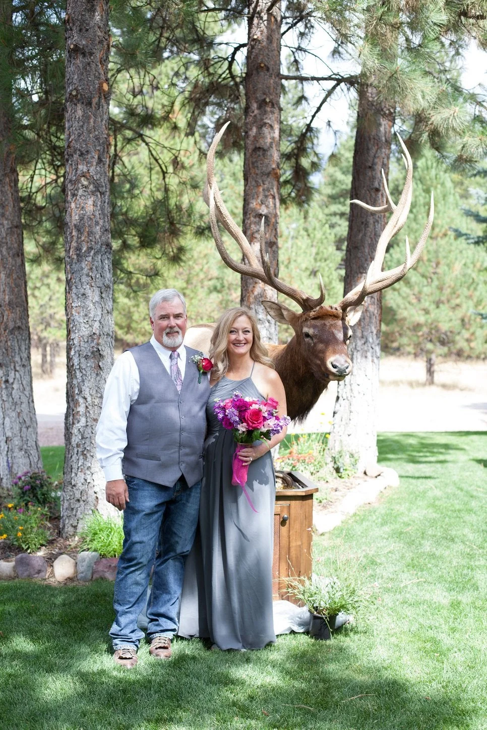 A hunter and his bride pose in front of a world-record elk shoulder mount. 