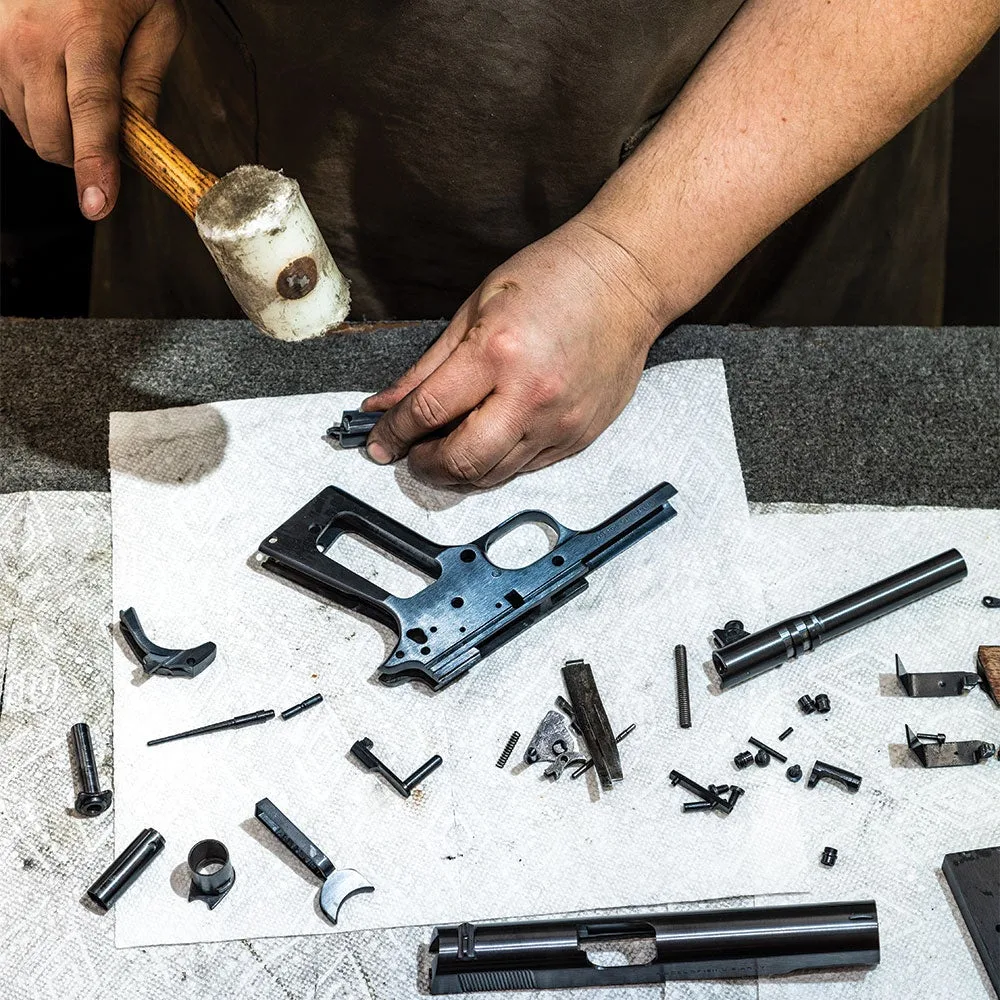 a gun smith with a disassembled handgun