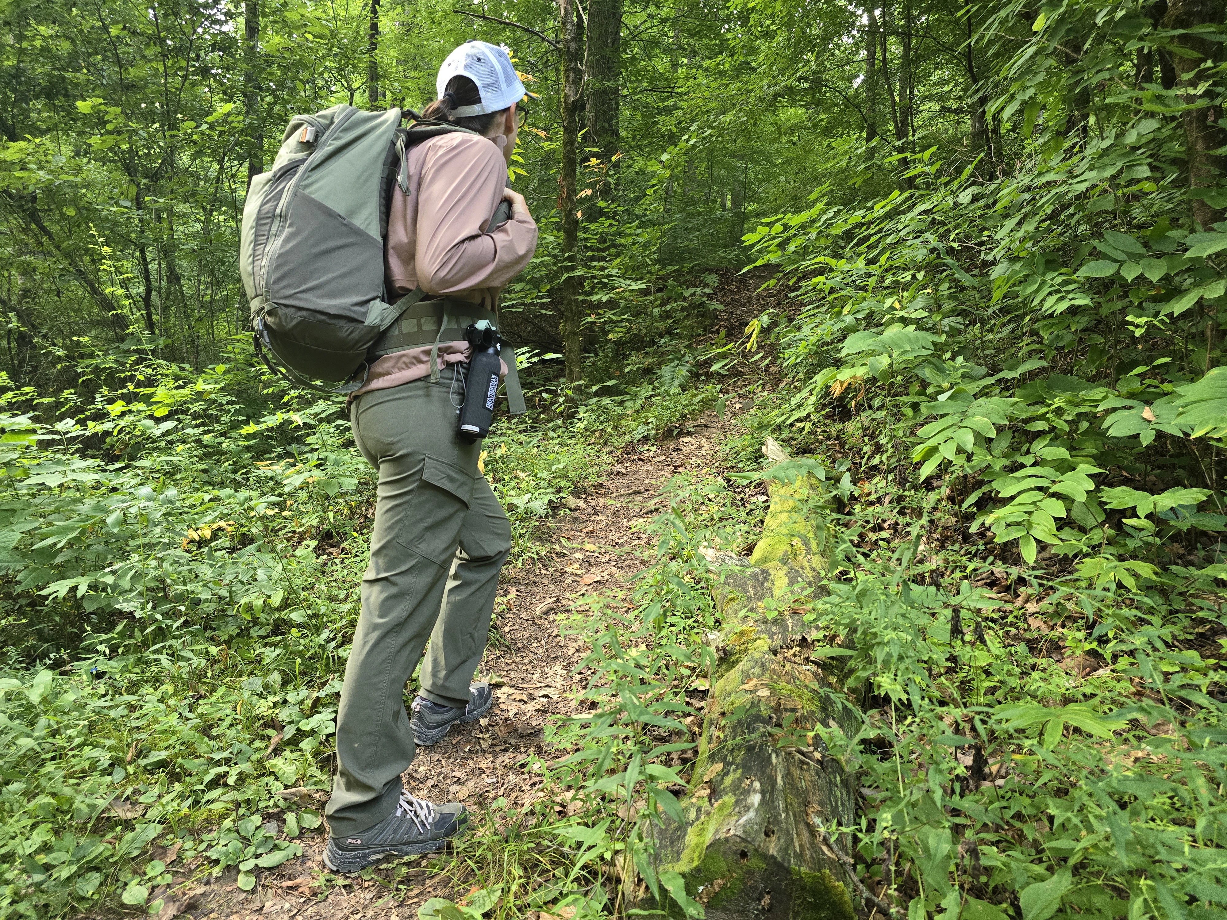 Woman hiking with holster holding bear spray