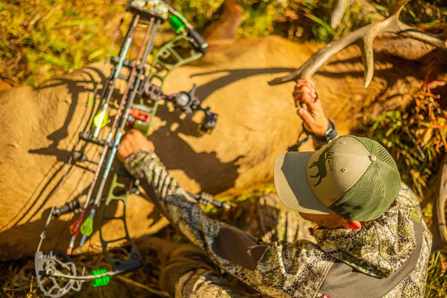 Hunter over an elk taken with a compound bow