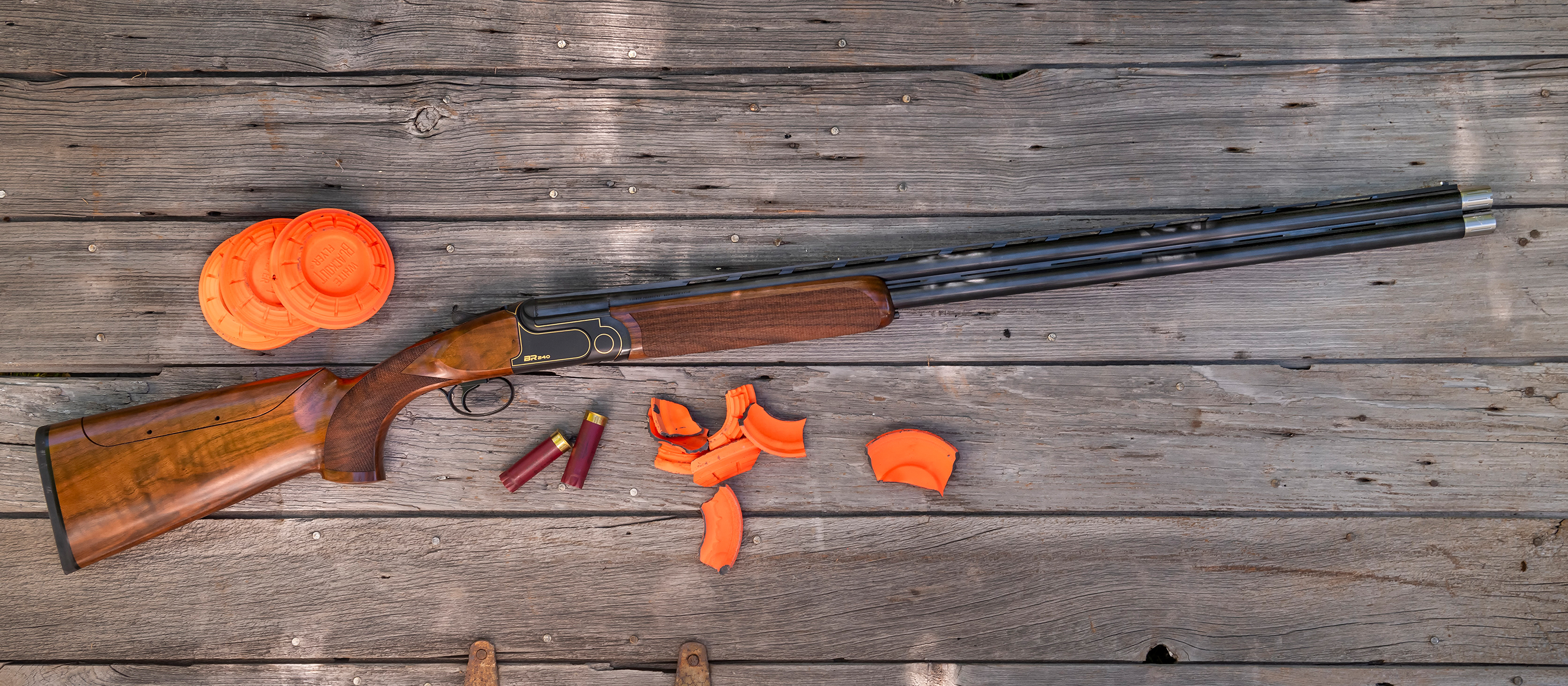 Rizzini BR240 Cole Special Sporting shotgun on a wood surface with clay targets. 