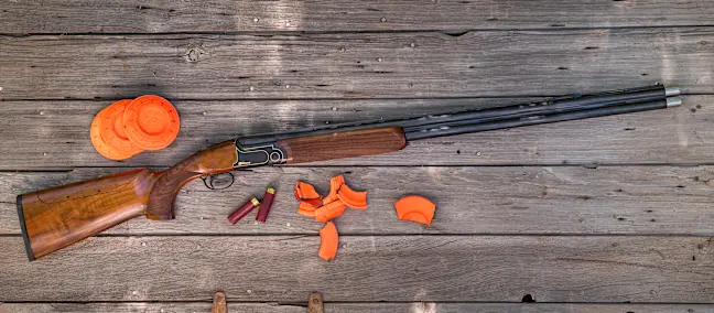 Rizzini BR240 Cole Special Sporting shotgun on a wood surface with clay targets. 