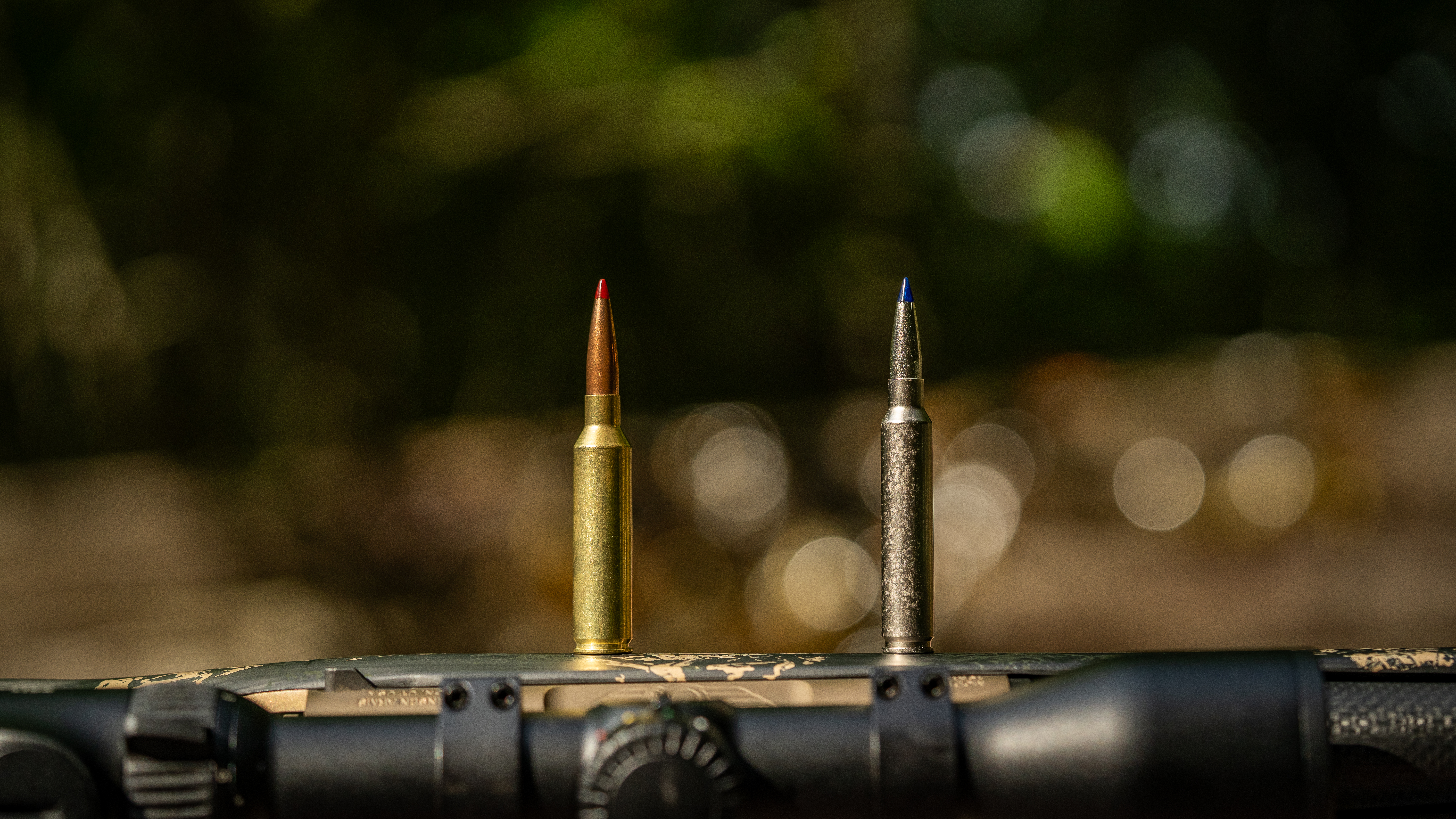 7mm PRC vs 7mm Backcountry cartridges, resting on the side of a rifle stock