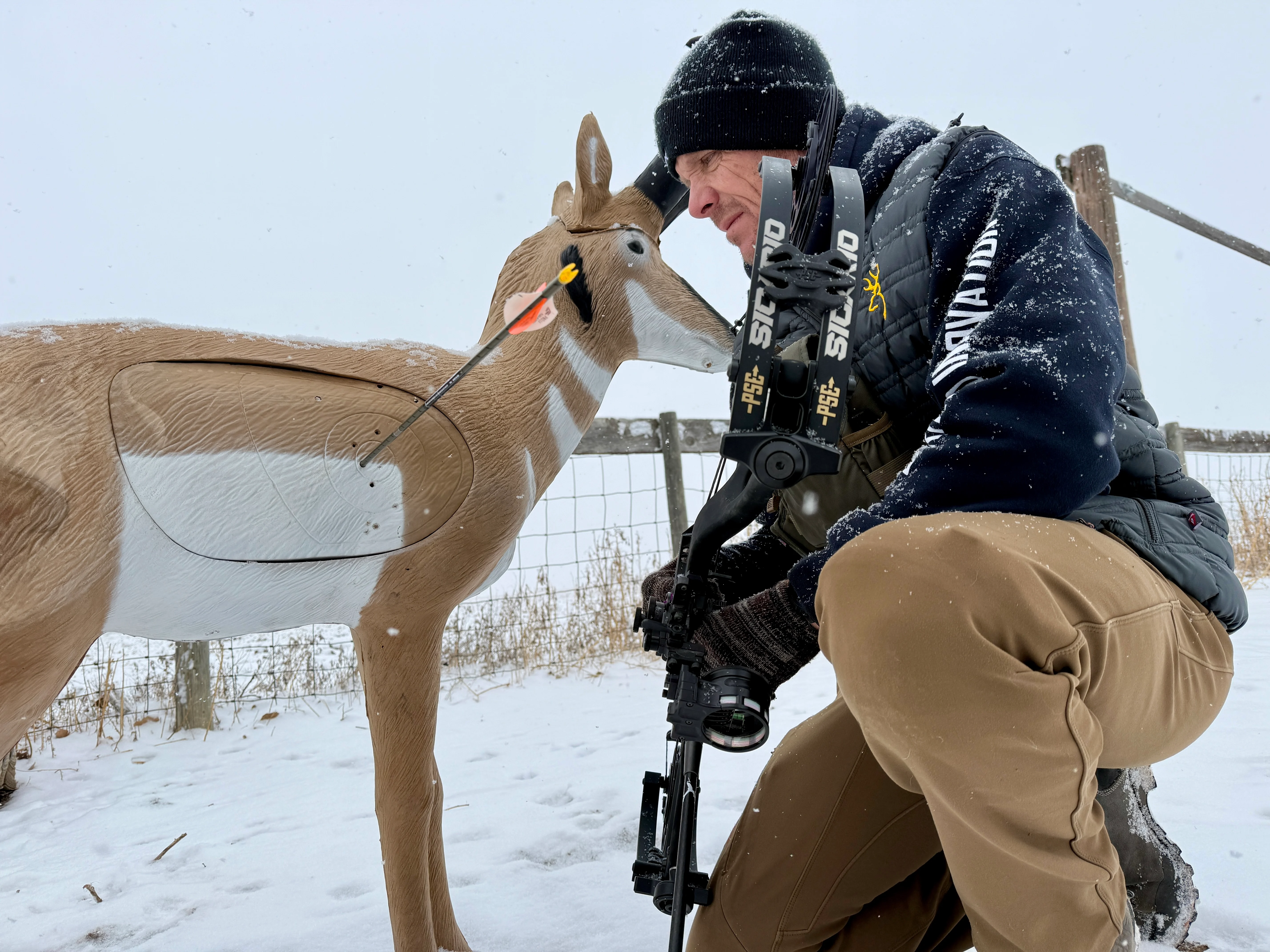 An archer admires an arrow in a target shot with the new PSE Sicario compound bow.