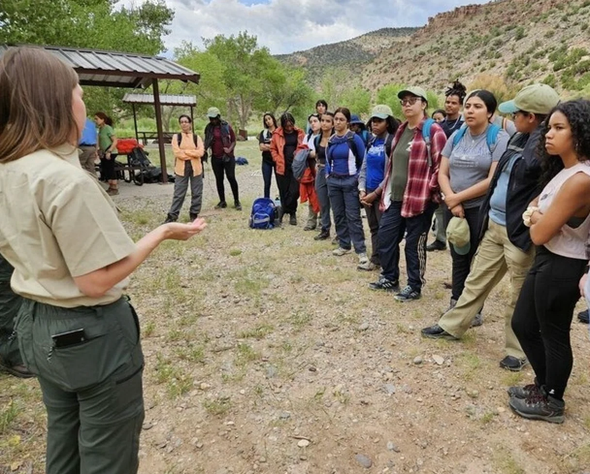 A Forest Service employee speaks to hikers at a trailhead. 