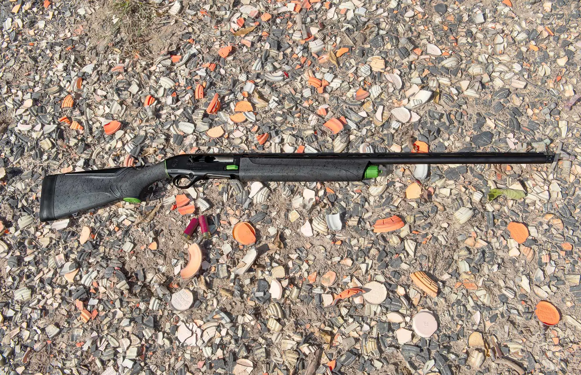 Beretta A300 Ultima Sporting shotgun lying on the ground at a clay target range.