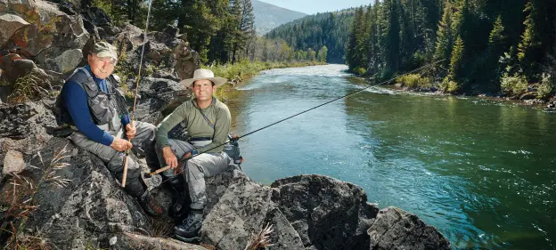 yvon chouinard and kenton carruth sitting on rocks by stream