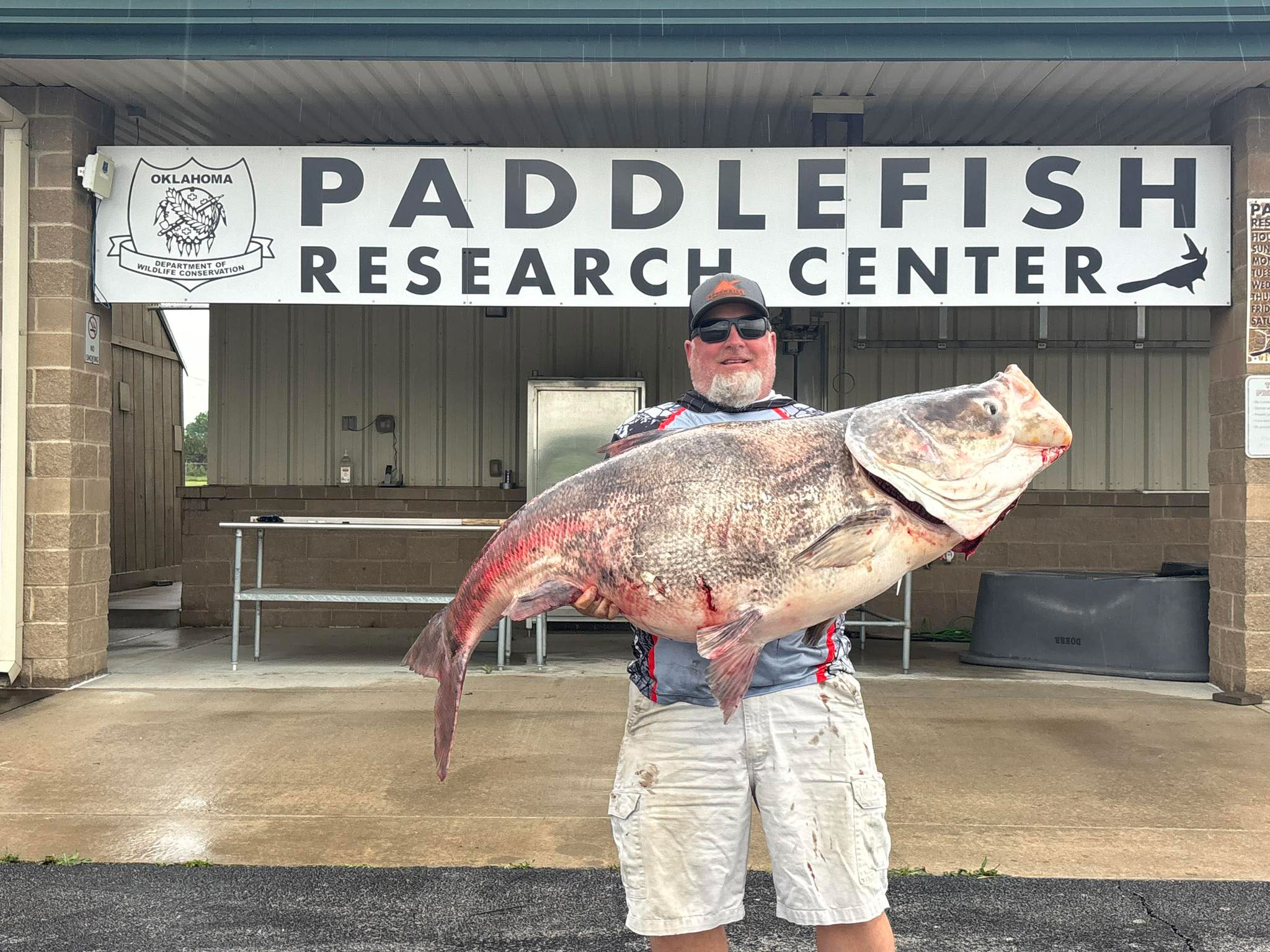 An angler poses with a record-breaking carp. 