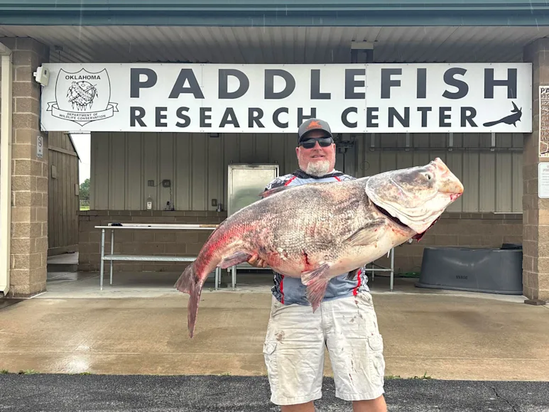 An angler poses with a record-breaking carp.