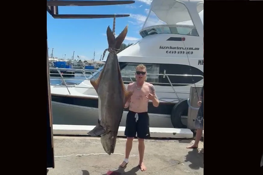 An angler poses with a pending-record cobia.
