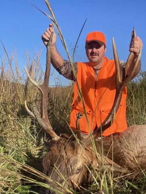 hunter poses with large bull elk