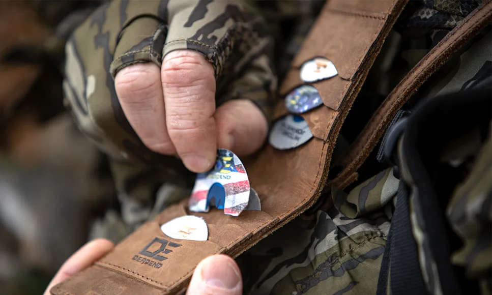 A hunter's pulls a turkey mouth call from a sleeve that holds multiple calls.