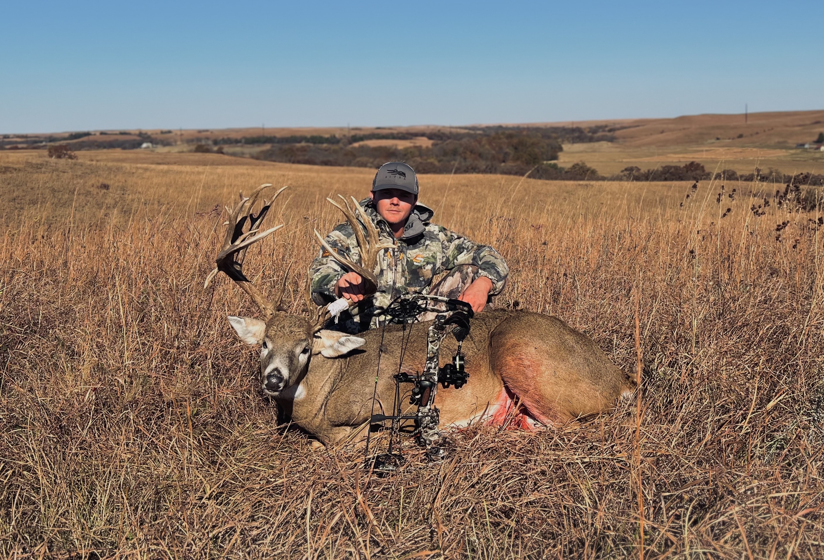 Kansas hunter poses with a trophy whitetail buck on the Kansas prairie. 