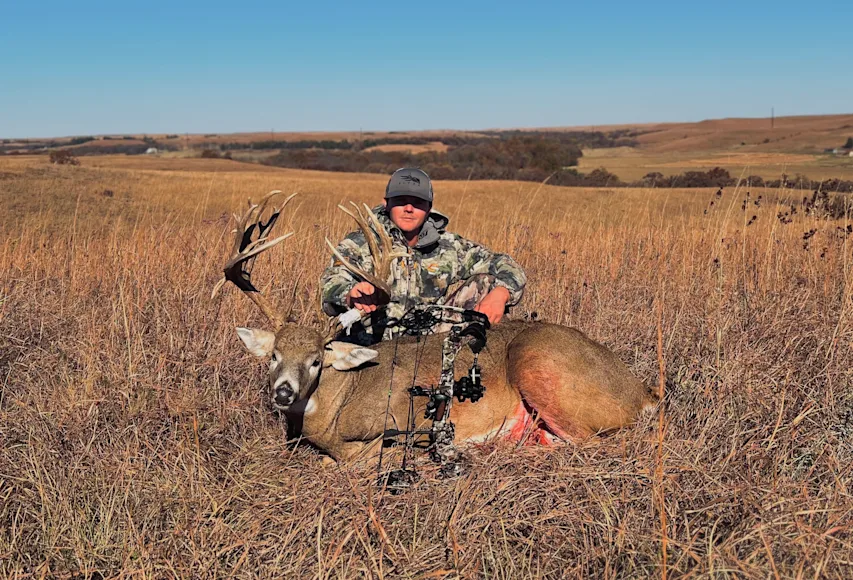 Kansas hunter poses with a trophy whitetail buck on the Kansas prairie.