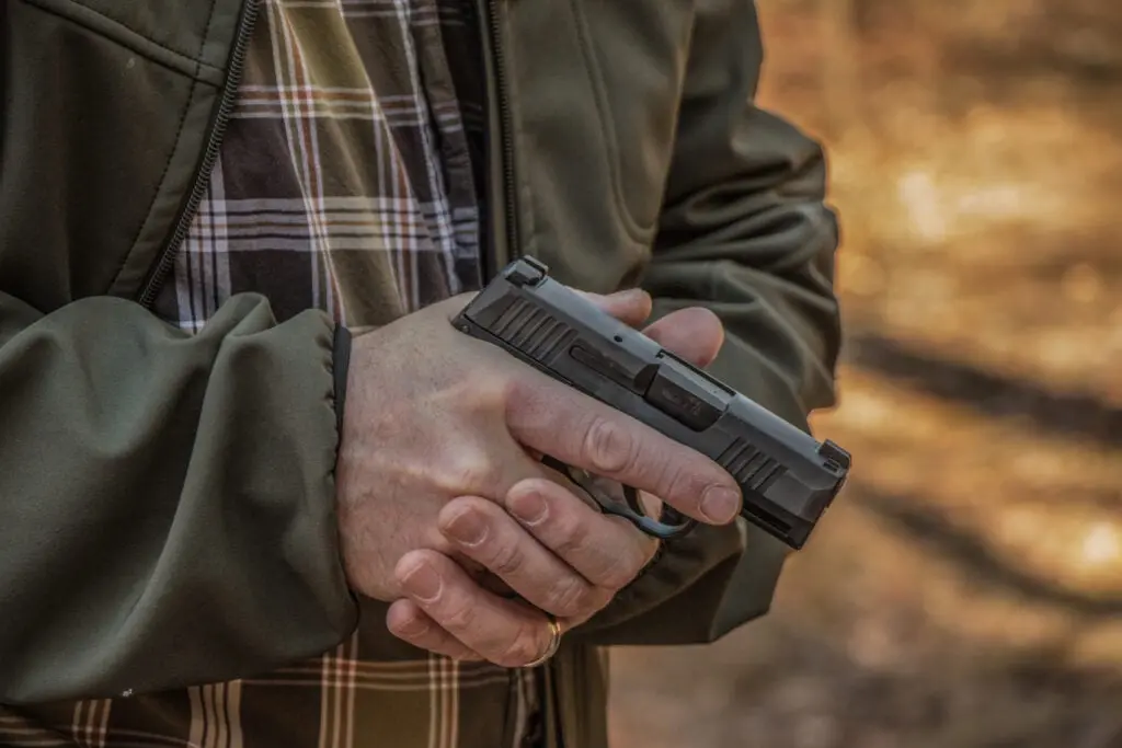 Man holding handgun close to body