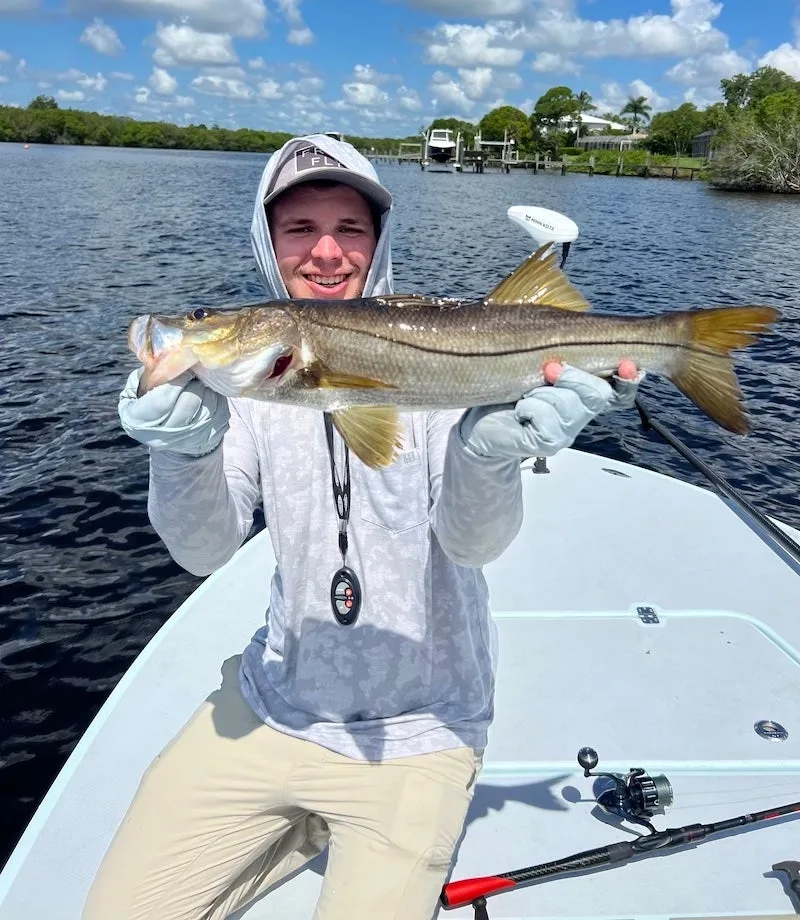 Angler holding fish on a boat wearing Grundens Gaff fishing pants