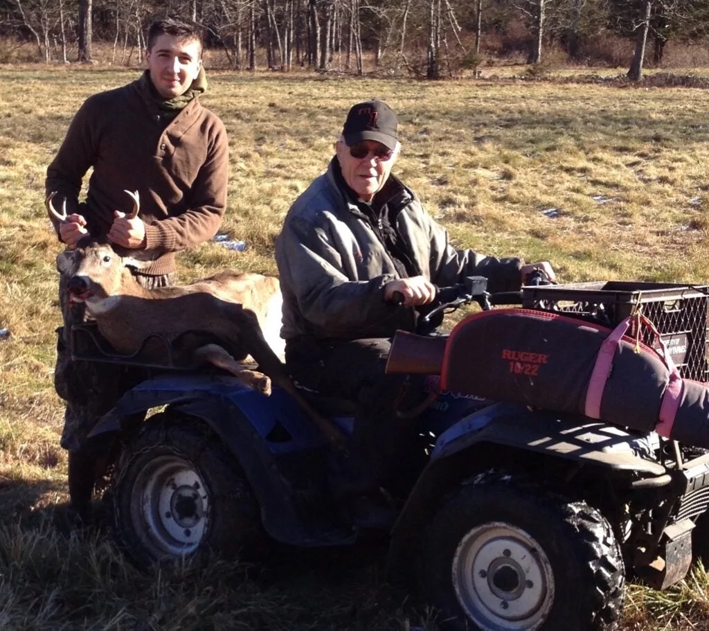 The author and his grandpa haul a buck back from the woods.