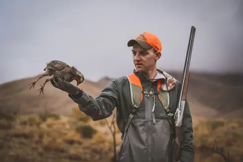 hunter holding chukar and benelli 828 shotgun