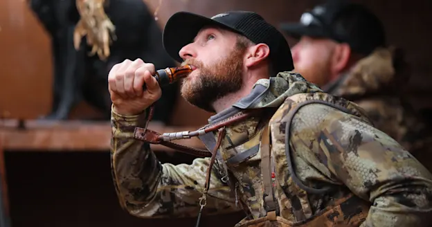 Waterfowl hunter using 737 Duck Call in blind
