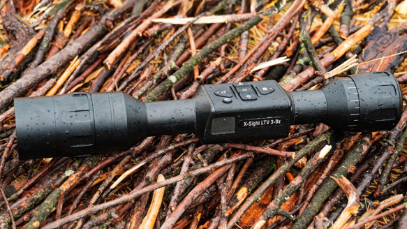 ATN thermal rifle scope sitting on grass