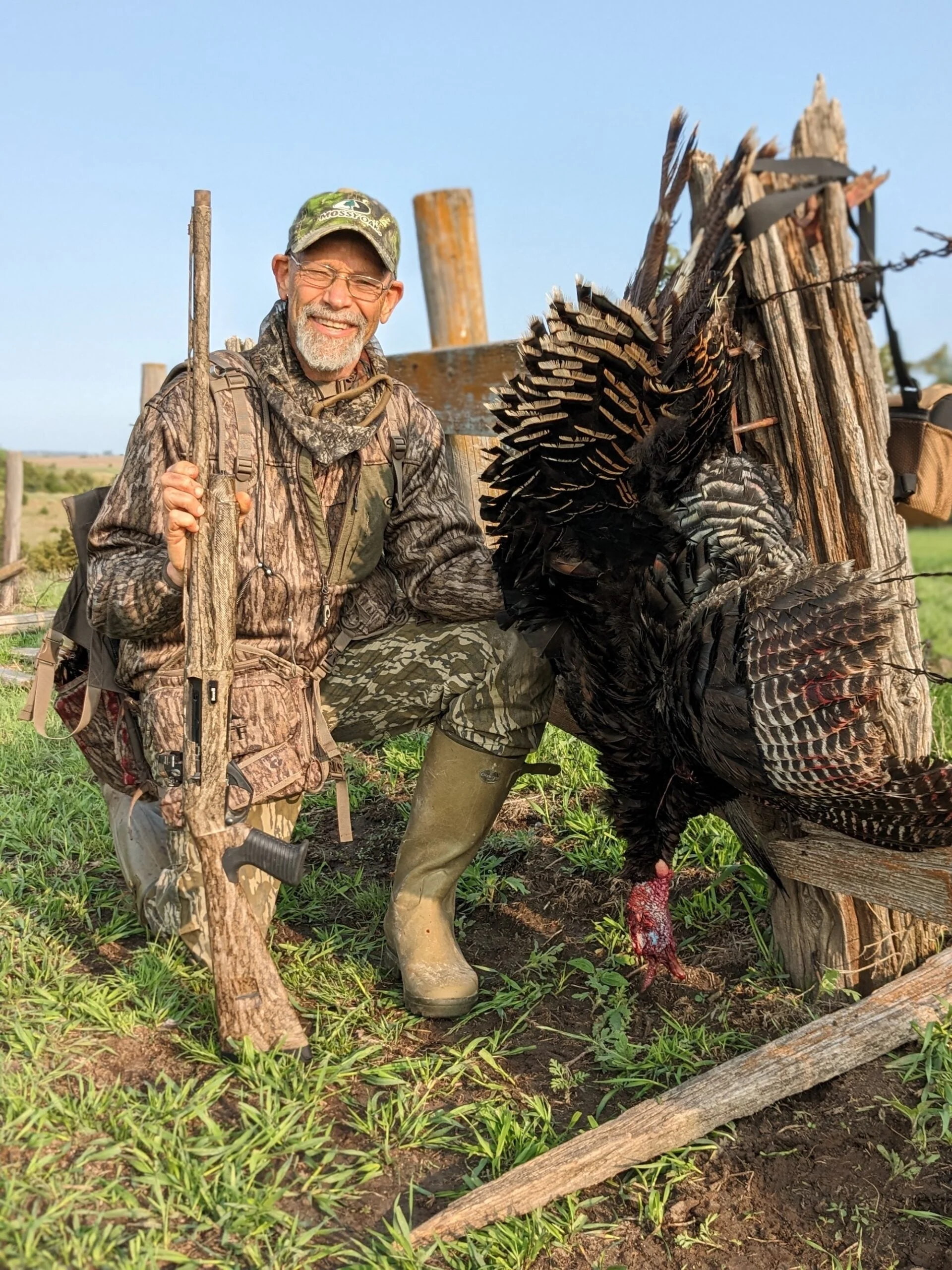 Man with a shotgun and a dead turkey