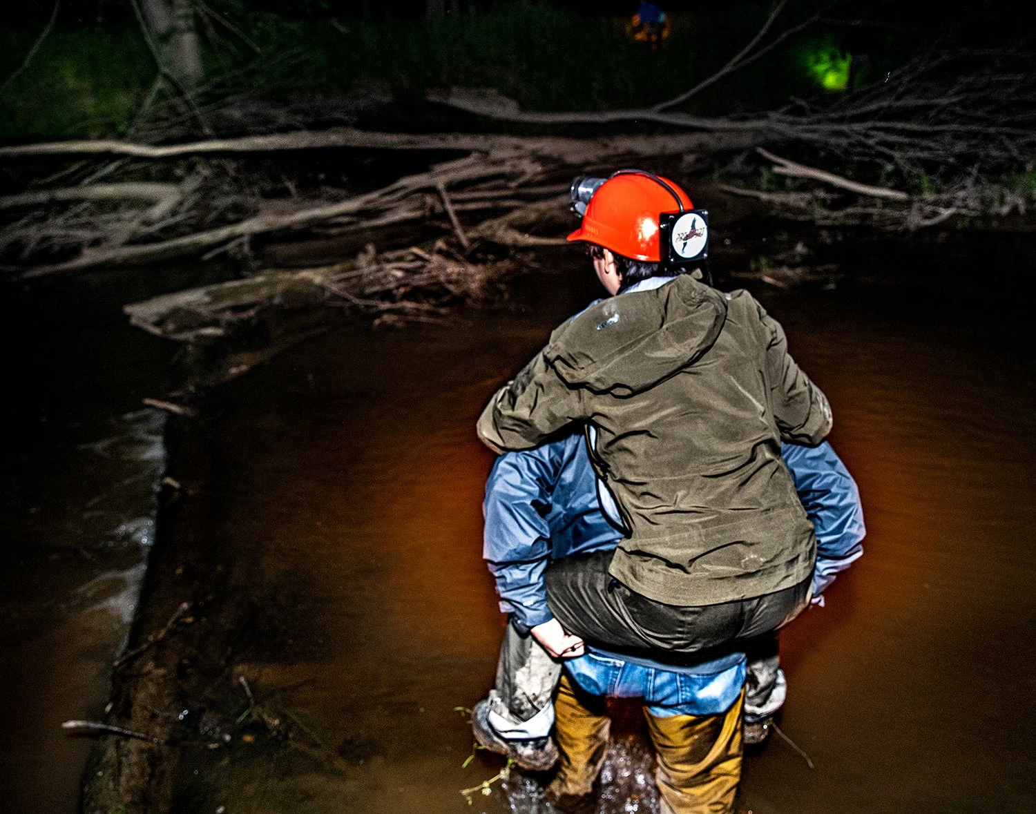 raccoon hunter carries spectator across deep water via piggyback