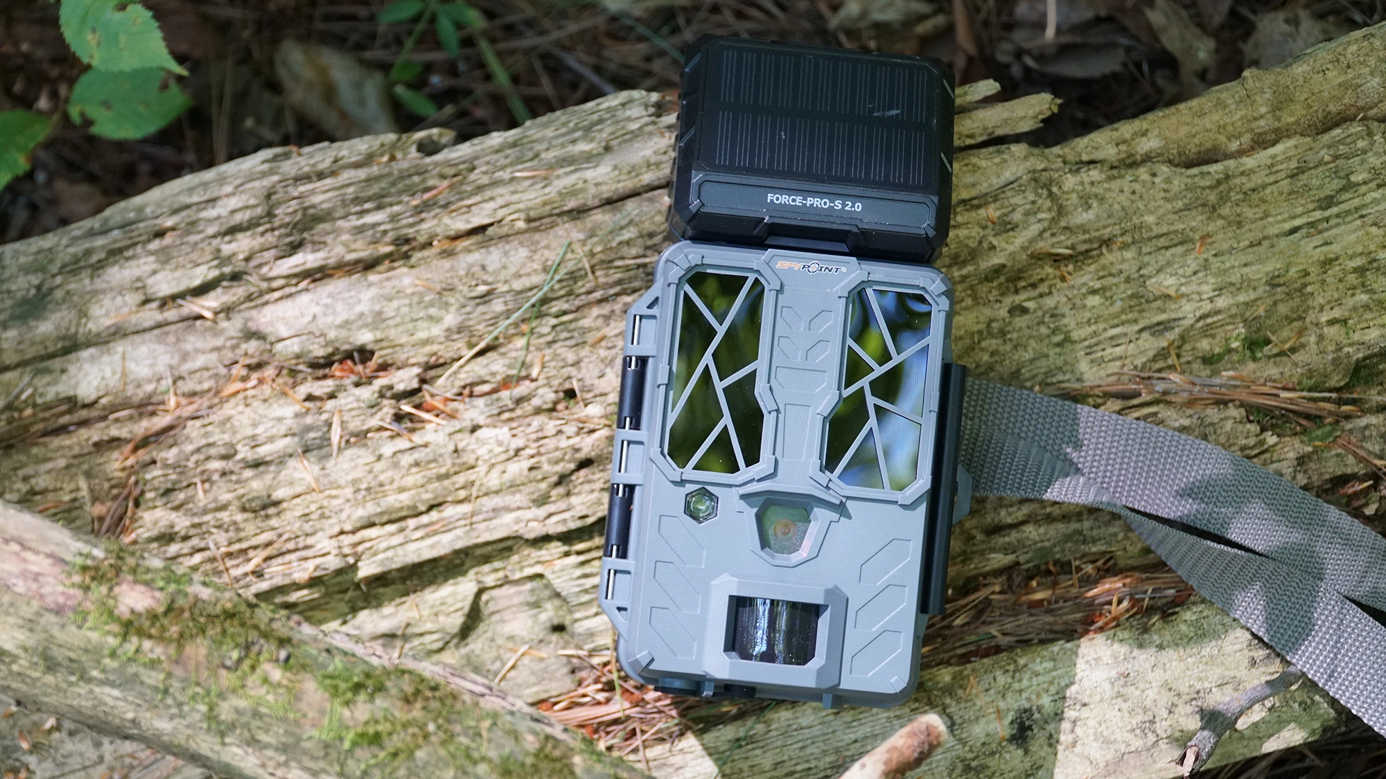 Spypoint Force Pro S 2.0 trail camera lying on a log. 