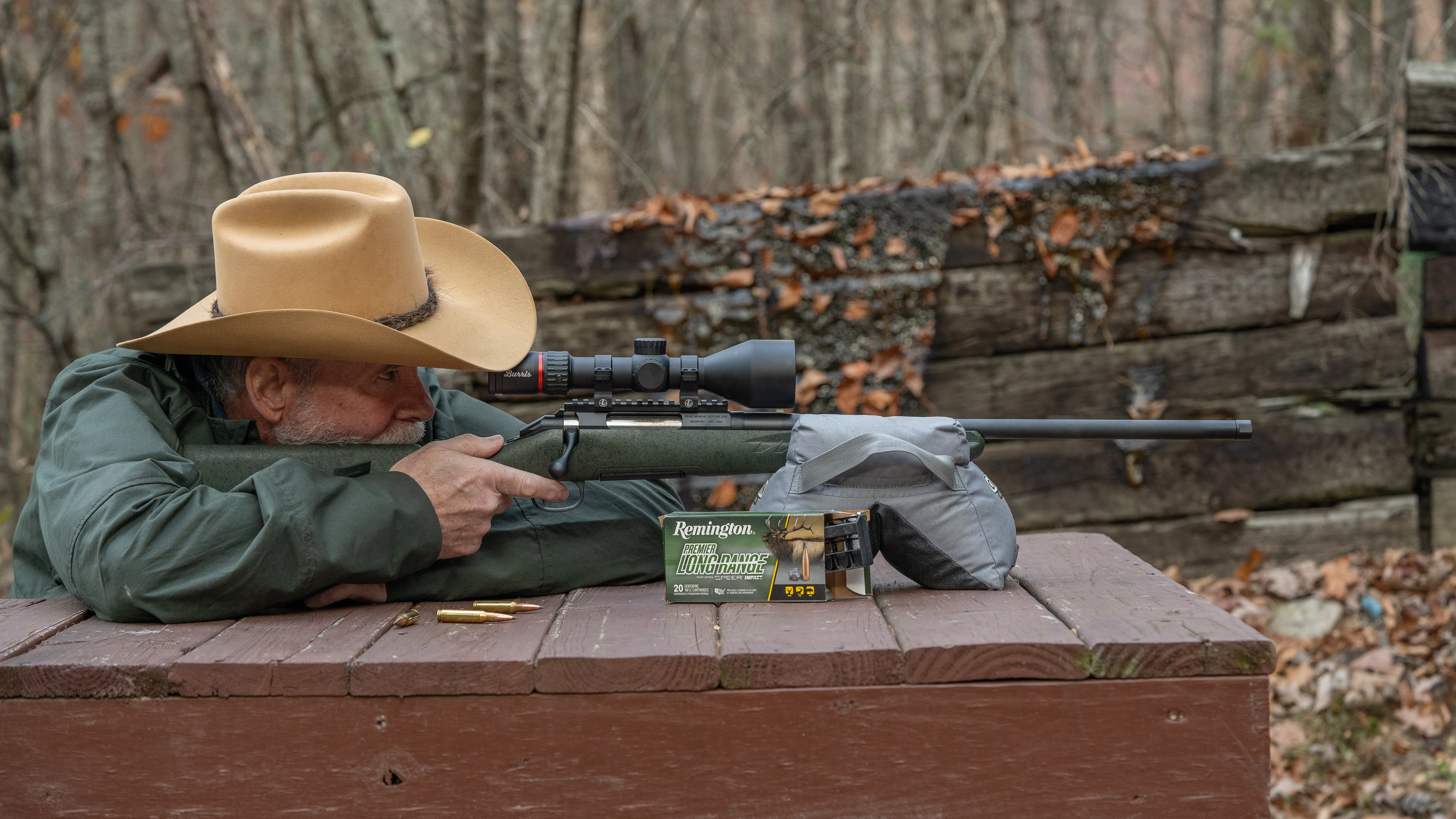 A shooter fires a Genfield Model A rifle from a bench rest. 